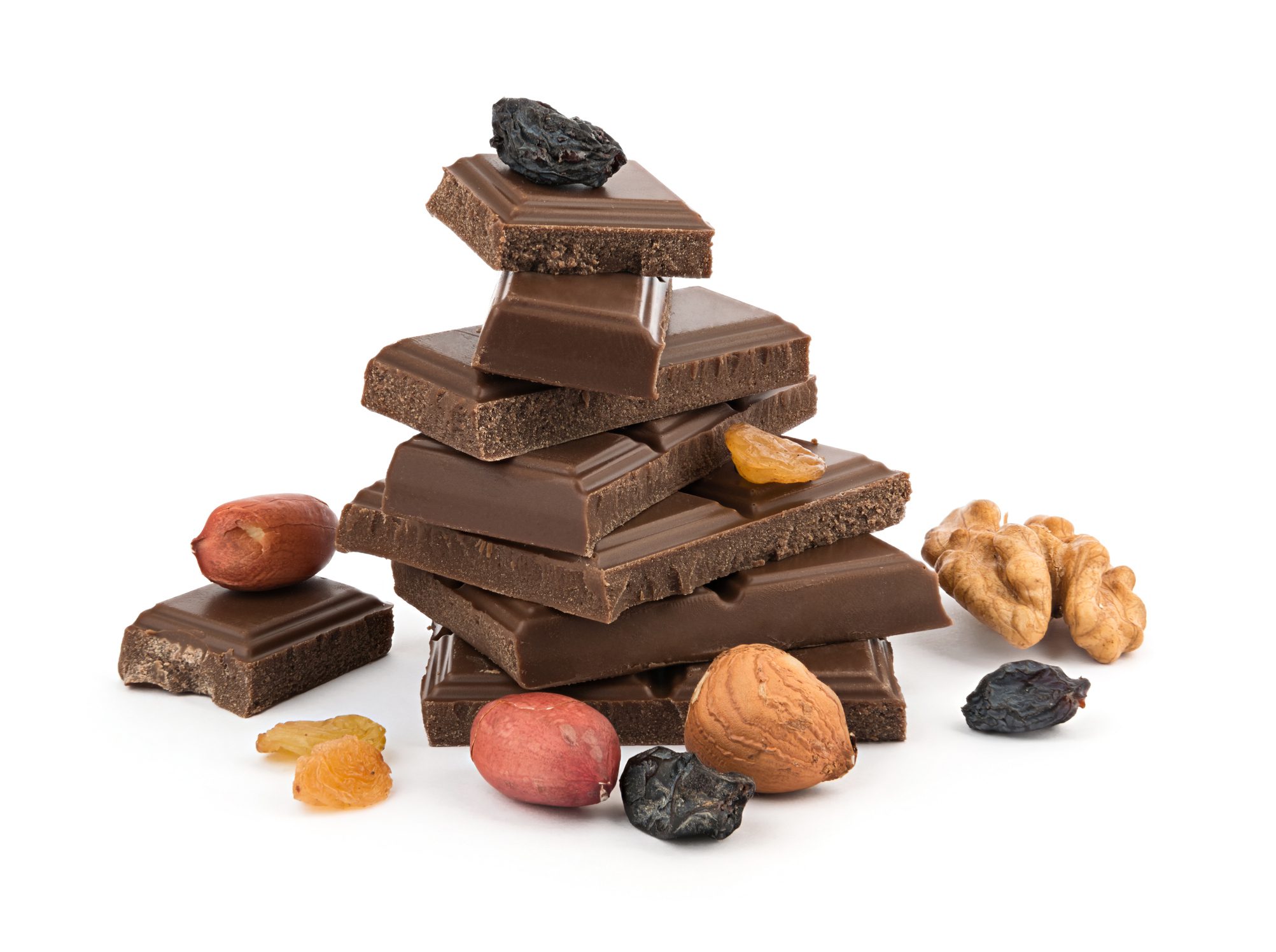 Heap of chocolate bars with nuts and raisins isolated on white background Chocolate pieces with assorted nuts and fruits.