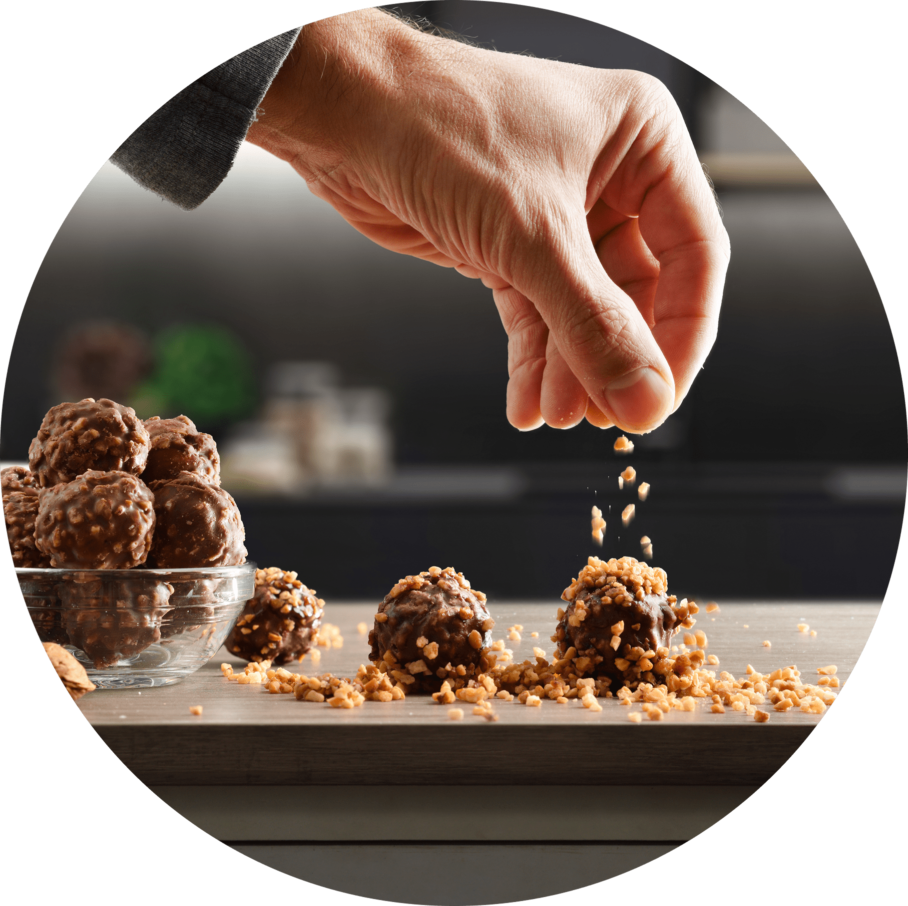 Group 1321317517 Hand sprinkling nuts on chocolate truffles.
